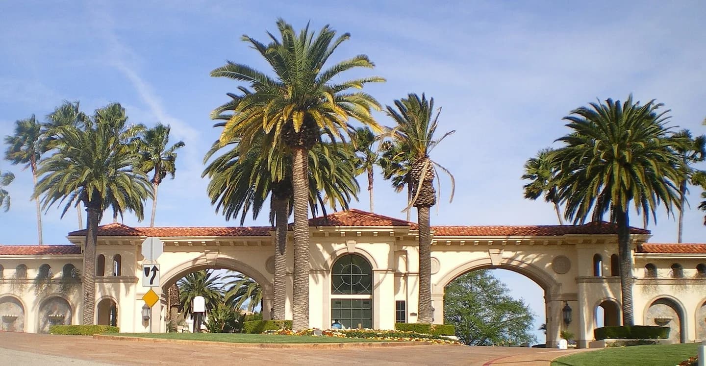 Mulholland Park Gate and gatehouse — southern Reseda Boulevard, Tarzana, Los Angeles, California. Canary Island date palms (Phoenix canariensis).